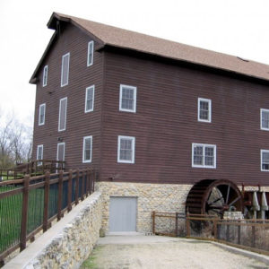 brown mill with stone foundattion and water wheel